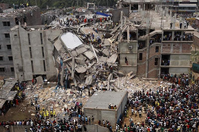 Man sieht das eingestürzte Fabrikgebäude Rana Plaza in Bangladesch umringt von Menschen.